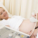 Pregnant woman getting ultrasound from doctor