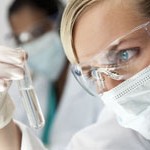 Female Scientific Research Team With Clear Solution In Laborator