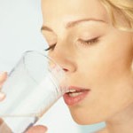 Young beauty blonde woman drinking mineral water
