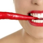 Beautiful woman teeth eating red pepper